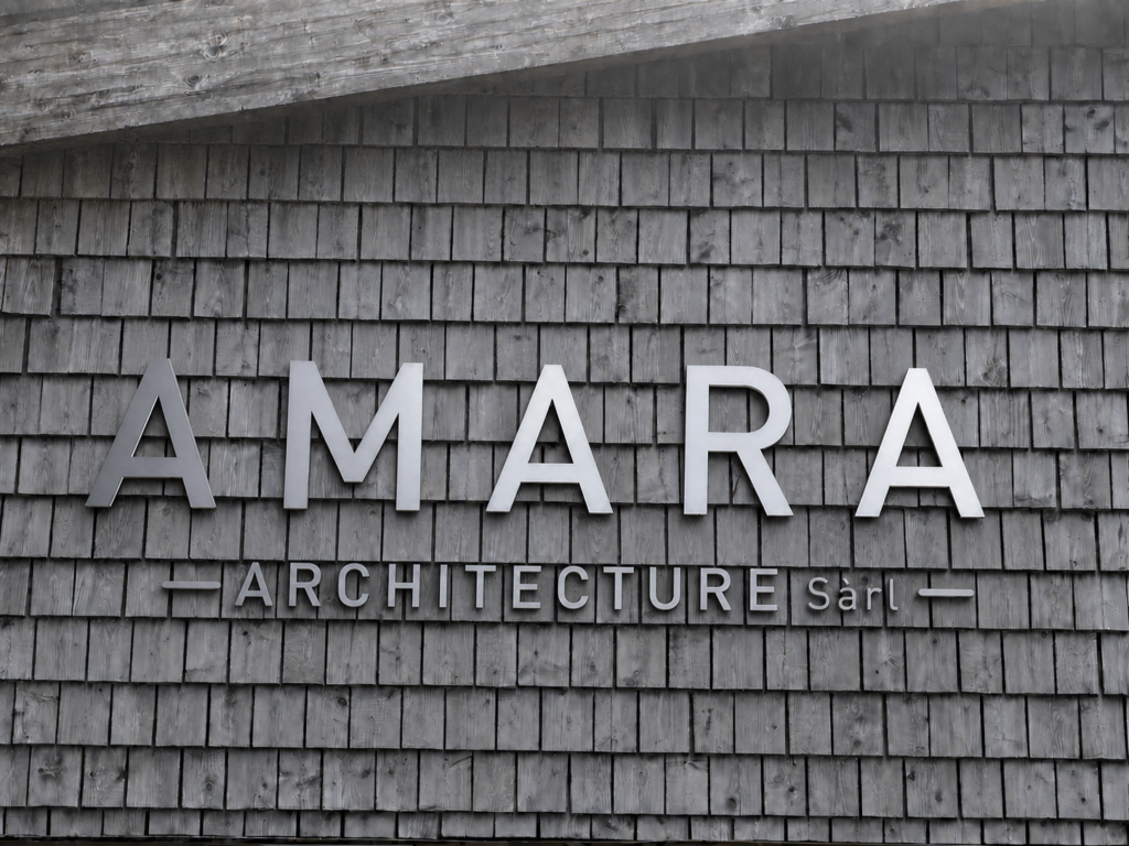 Logo AMARA Architecture Sàrl sur bardage en bois